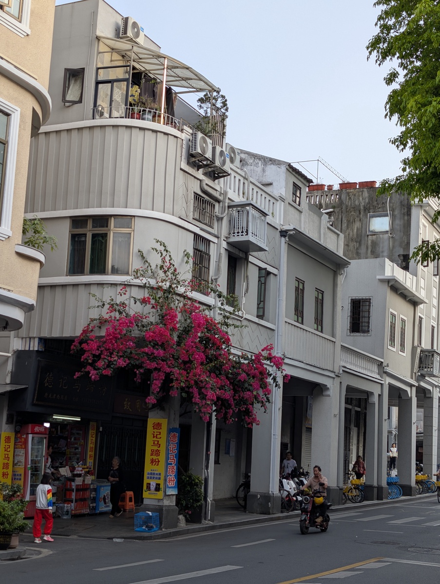 A street scene with buildings overhanging the sidewalk