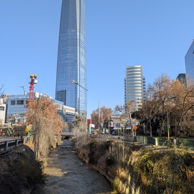 A tall, blue glass skyscraper in a city landscape.